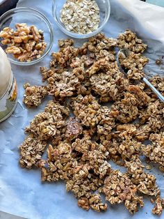 granola and yogurt are being prepared on a sheet of paper with spoons