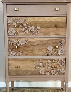 a wooden dresser with flowers painted on the front and drawers in gold, silver or pink