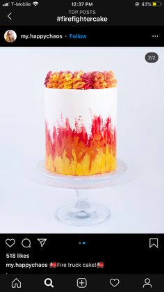 a cake with red, yellow and orange frosting sitting on top of a table