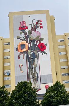 a large mural on the side of a building with flowers and birds in it's center