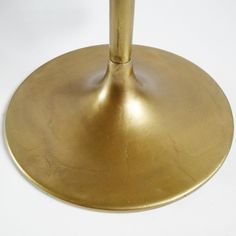 an umbrella is shown on a white surface with a gold colored base and black top