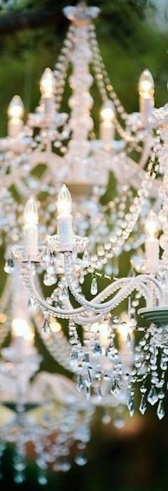 a chandelier with many lights hanging from it's sides in a garden