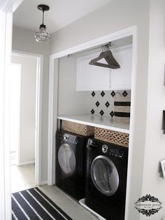 a washer and dryer in a small laundry room with black and white decor