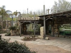 an outdoor area with stone walls and trees