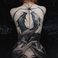 the back of a woman's body with a dragon and star tattoo on it