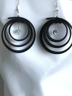 a pair of black hoop earrings on a white mannequin