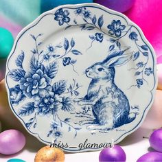 a blue and white plate with an image of a rabbit on it next to eggs