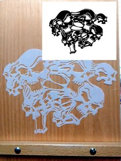 an image of a wooden plaque with skulls on it and a sticker next to it