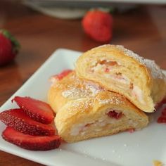 two pastries on a white plate with strawberries