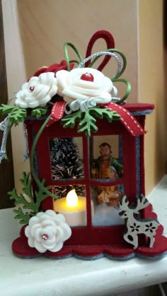 a small red box with flowers and a candle