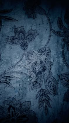 an old wallpaper with flowers and leaves on it's blue color scheme in the dark