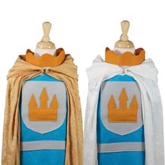 two blue and white costumes with yellow crowns on them, one is wearing a cape