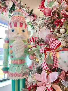 a christmas tree decorated with pink and green ornaments, including a nutcracker ornament