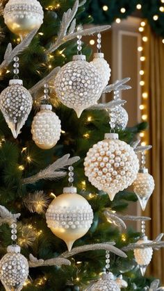 a christmas tree with ornaments hanging from it's branches and lights on the top