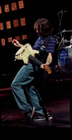 a man playing an electric guitar on stage