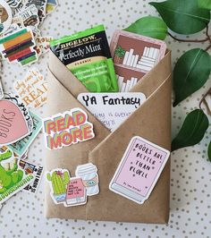 an envelope with stickers on it sitting next to a potted plant and some books