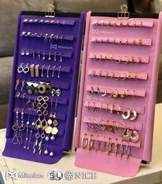 two purple and pink jewelry racks with earrings on them