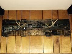 an antlers head mounted to the side of a wooden wall