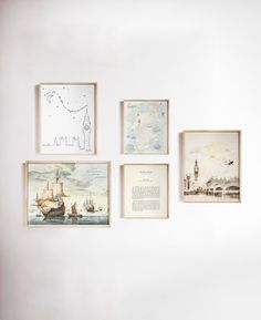 four framed pictures hang on the wall in front of a white wall with various drawings