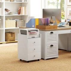 an office with a desk, filing cabinet and computer on the table in front of it