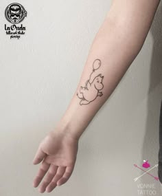 a person with a small tattoo on their arm holding onto a ballon in the air