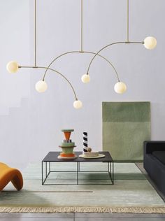 a living room filled with furniture and lights hanging over it's head on the wall