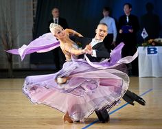 a man and woman dancing on a dance floor