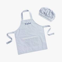 the taylor apron and hat set is shown in blue gingham with white trim