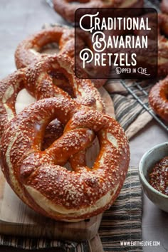 some pretzels are sitting on a wooden board next to a bowl of sauce