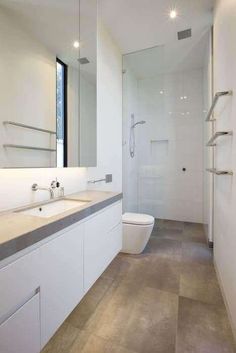 a bathroom with a toilet, sink and shower stall is pictured in this image from the front view