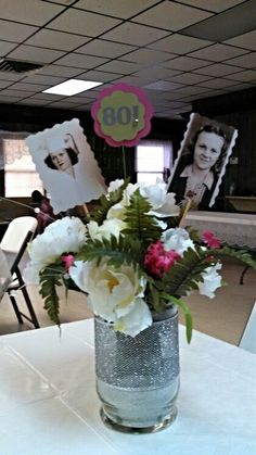 a vase filled with flowers sitting on top of a white table cloth covered tablecloth