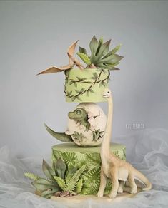 there is a cake decorated with plants and animals on it's top tiers