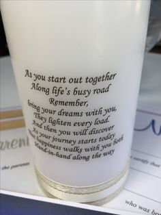 a white glass sitting on top of a table next to other papers and cups with writing on them