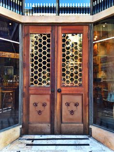 two wooden doors are open in front of a store