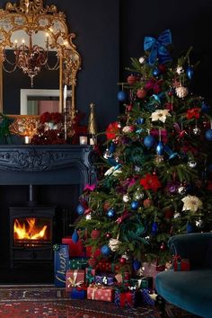 a decorated christmas tree in front of a fireplace