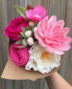 a person holding a bouquet of flowers in their hand