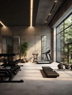 an empty gym with exercise equipment and yoga mats on the floor in front of large windows