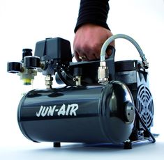 an air compressorer being operated by a man's hand on top of it