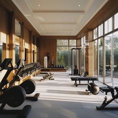 there are many exercise machines in this large home gym with lots of windows to let in natural light