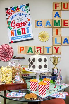 a game night party with popcorn, cake and snacks on a table in front of scrabble tiles