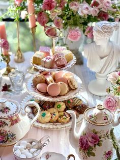 a table topped with three tiered trays filled with pastries and desserts