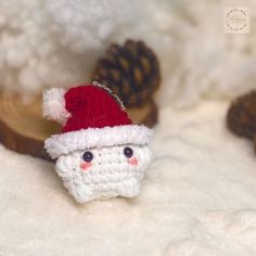 a small crocheted santa clause hat on top of a white fur covered surface