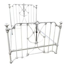 a white metal bed frame with two candles on each side