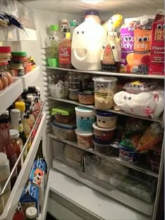 an open refrigerator filled with lots of food and condiments on the bottom shelf