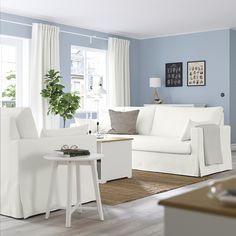 a living room with blue walls and white furniture