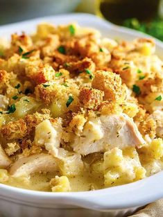 a white bowl filled with macaroni and cheese covered in chicken breast crumbs