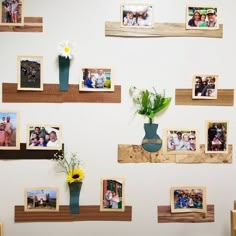 there are many pictures on the wall and vases with flowers in them, as well as frames