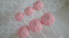 some pink cake pops sitting on top of a white plate