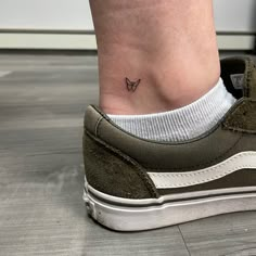 a woman's foot with a small butterfly tattoo on her left side ribcage