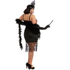 a woman in a black flap dress with feathers on her arms and legs, holding a wand